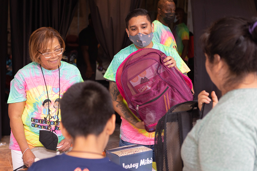 Photo of ACA Health Navigators handing out backpacks